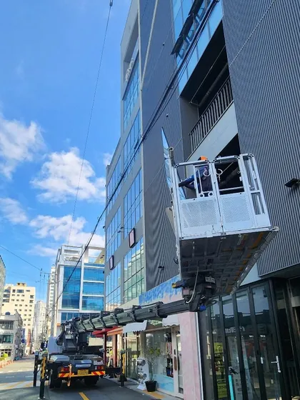 상가 빌딩 앞 스카이 장비로 유리 인양